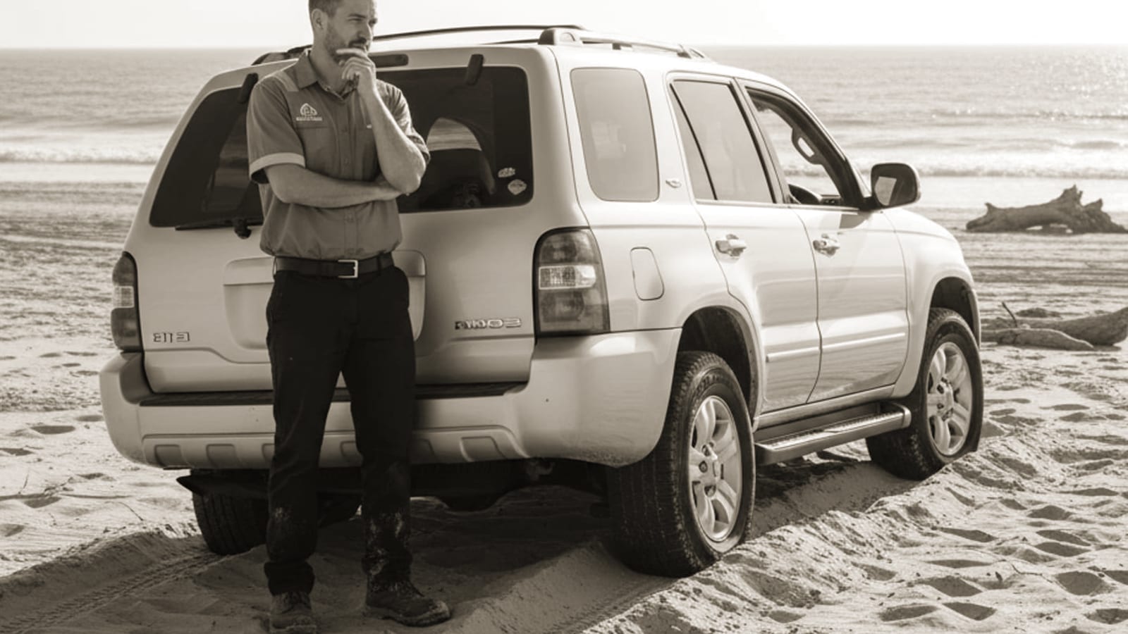 A car stuck in sand on a desert road east of El Paso with tire tracks